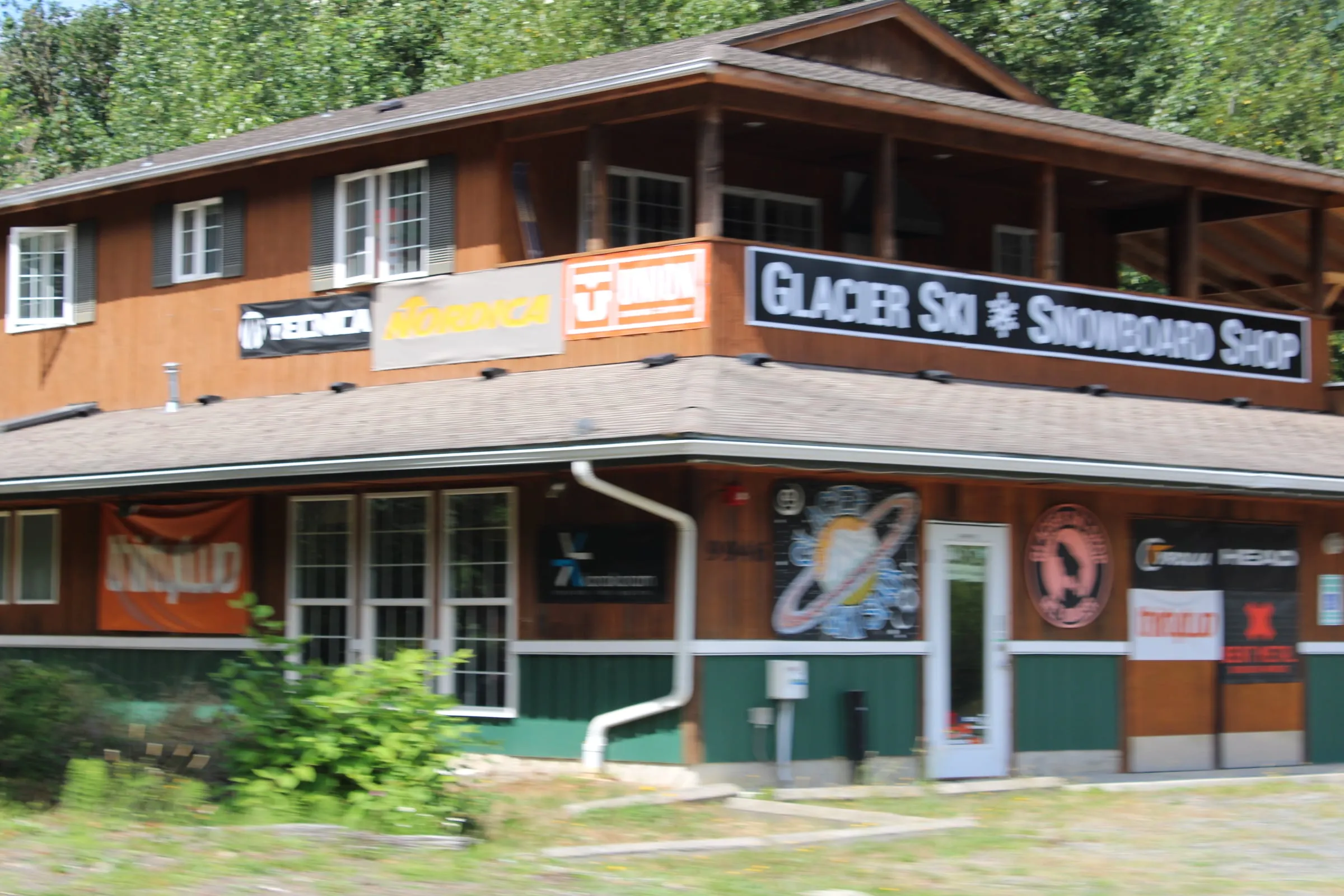 The wooden Glacier Ski and Snowboard Shop building on the Mt. Baker Highway with ski brand banners